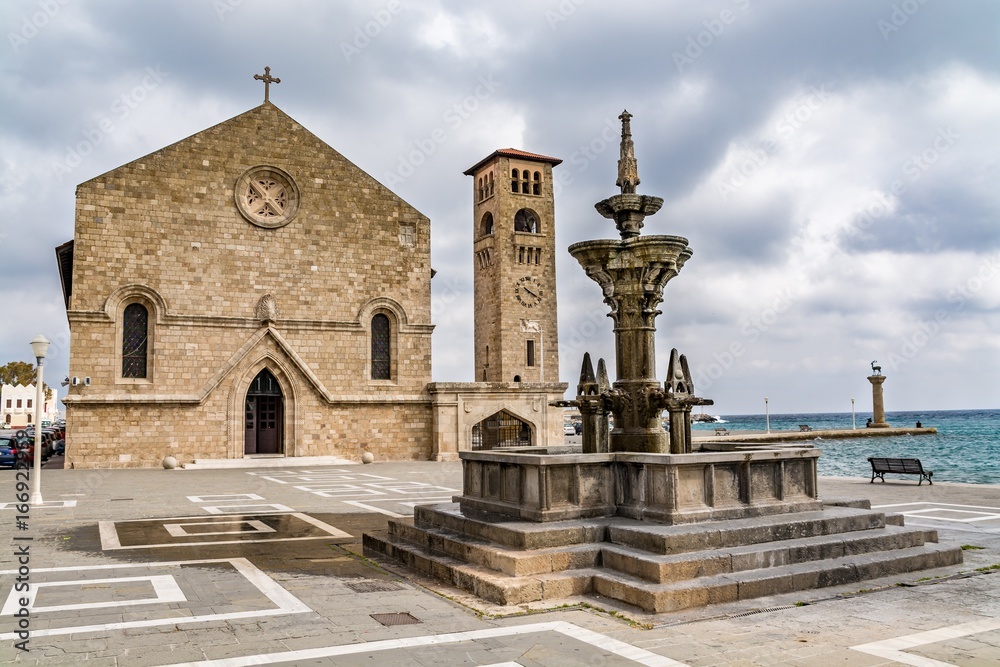 Obraz premium Evangelist Kilisesi orthodox church (Ekklisia Evaggelismos) and Mandraki fountain, Rhodes, Greece