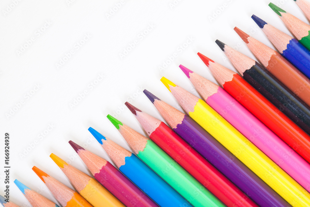 A drawing tool. Objects for creativity. Colored pencils on a light background in a diagonal line.
