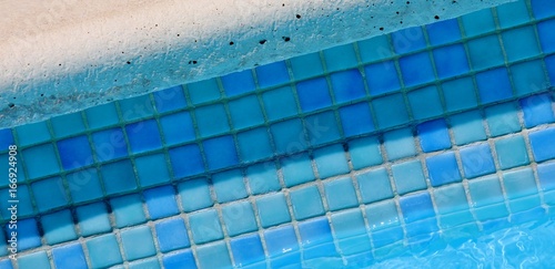 Pool side with blue tiles and clear water