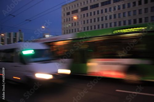 The bus and minibus traffic at dusk along the street with motion blur 