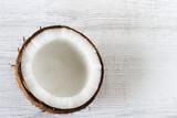 Coconut cut in half on white wooden background