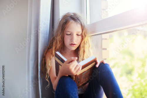 Girl reading book at home