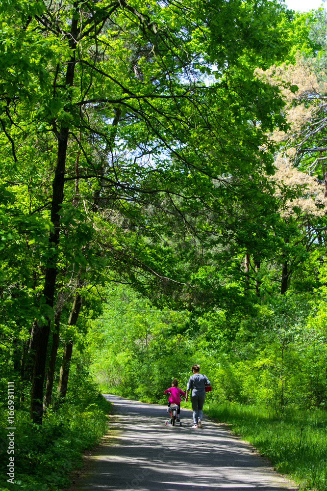 Dabushka and granddaughter ride a bicycle in the city park. May 28, 2017. Dabushka and granddaughter ride a bicycle in the city park. May 28, 2017.