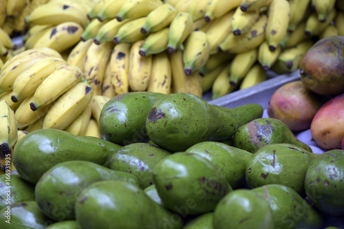 Avocados with bananas in the background in open air market