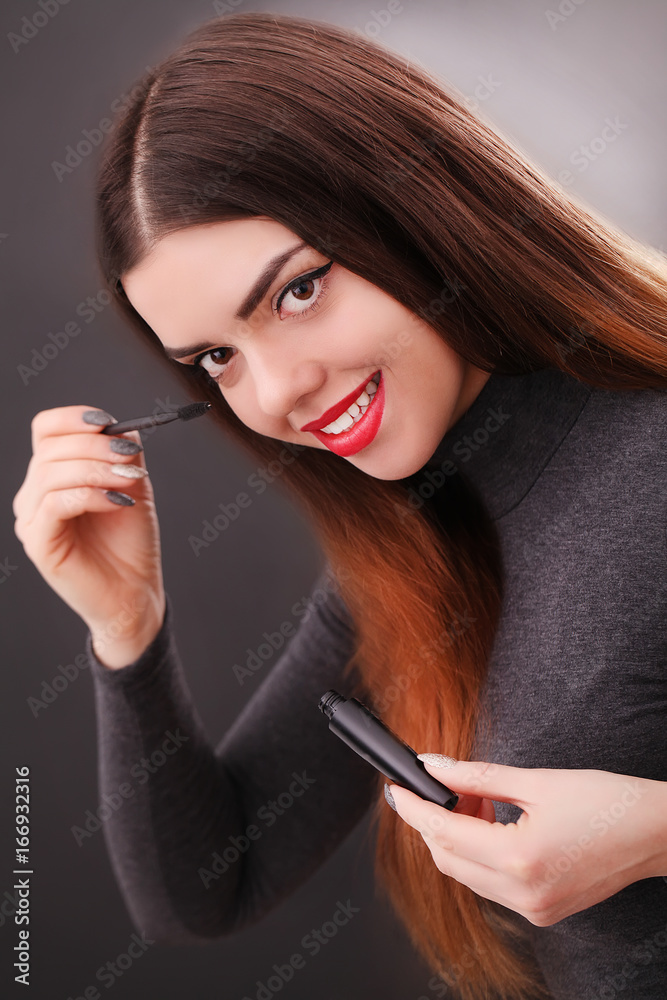Make-up and cosmetics concept. Asian woman doing her makeup eyelashes dark mascara. Make-up and cosmetics concept. Asian woman doing her makeup eyelashes dark mascara.