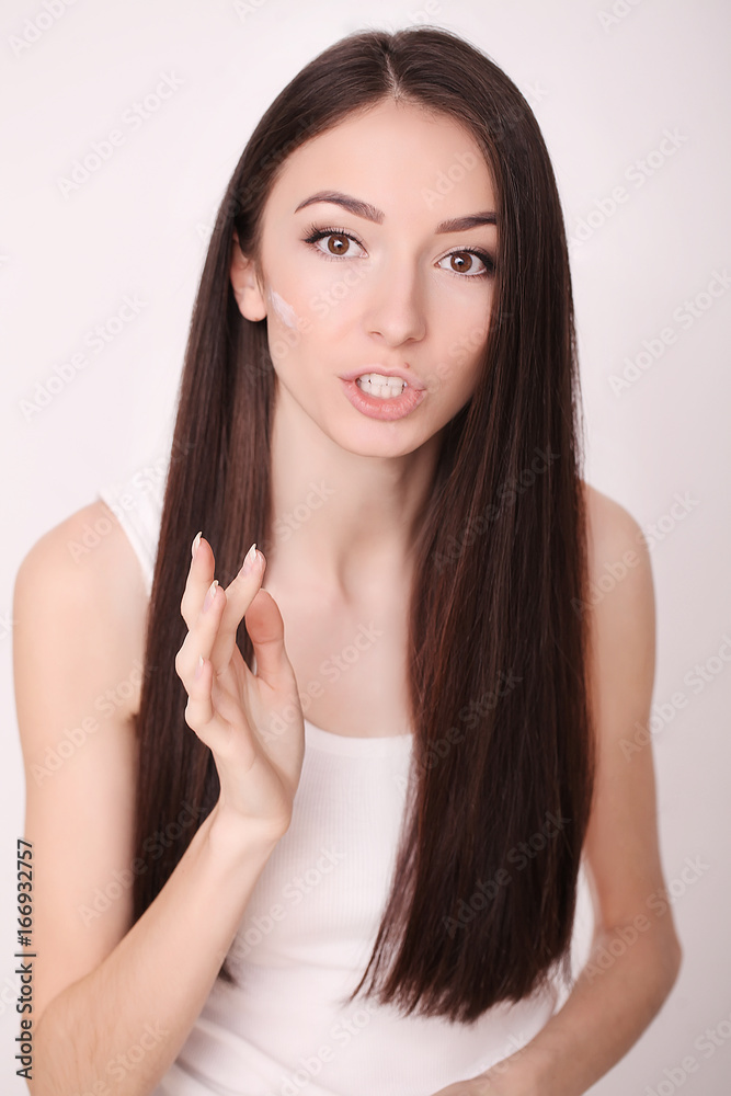 Attractive girl putting anti-aging cream on her face Attractive girl putting anti-aging cream on her face
