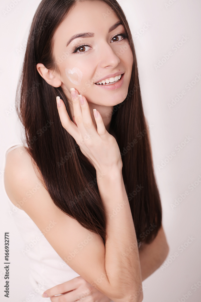 Young woman applying beauty cream, portrait Young woman applying beauty cream, portrait