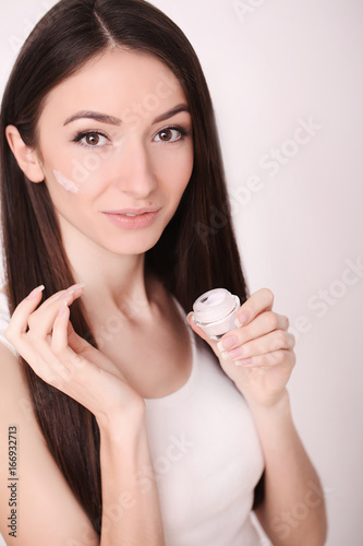 A beautiful woman asia using a skin care product  moisturizer or lotion and Skincare taking care of her dry complexion. Moisturizing cream in female hands