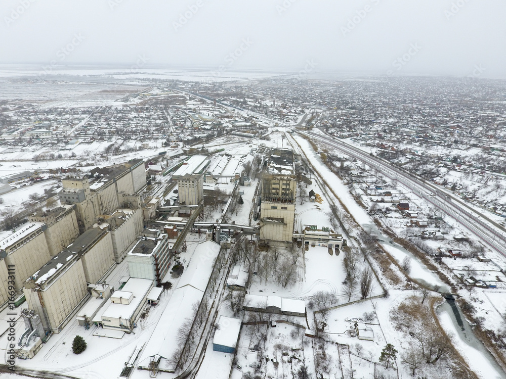 Sprinkled with snow grain elevator. Winter view of the old Soviet elevator. Winter view from the bird's eye view of the village. The streets are covered with snow Sprinkled with snow grain elevator. Winter view of the old Soviet elevator. Winter view from the bird's eye view of the village. The streets are covered with snow