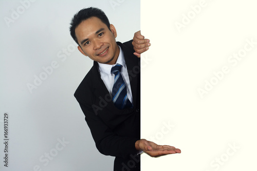 Photo Image of young asian businessman holding a blank sign with showing gesture