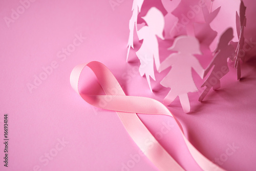 The Sweet pink ribbon shape with girl paper doll on pink background for Breast Cancer Awareness symbol to promote in october month campaign