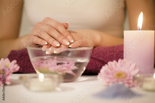 Woman hands in a nail salon receiving a hand scrub peeling by a beautician. SPA manicure, hand massage and body care, spa treatments.