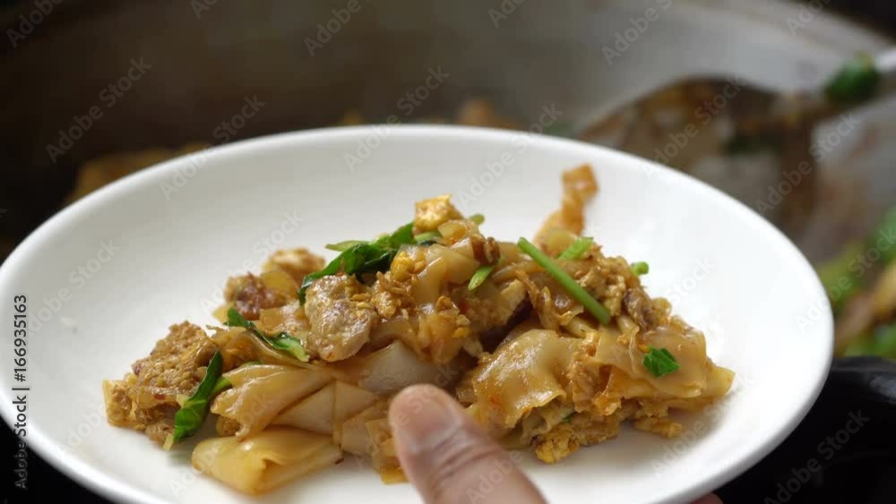 Ladling fried noodle with pork into plate, Thai food
Ladling fried noodle with pork into plate, Thai food