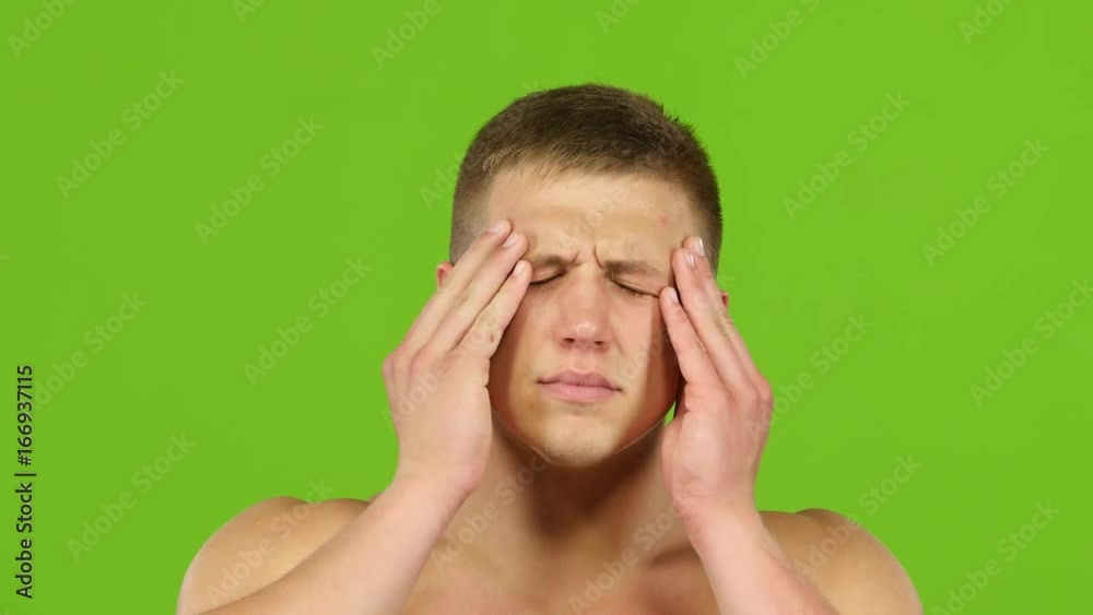 Man with headache is massages temples hands, green screen. Closeup Man with headache is massages temples hands, green screen. Closeup