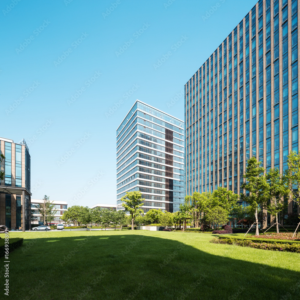 modern buildings near meadow in midtown of modern city modern buildings near meadow in midtown of modern city