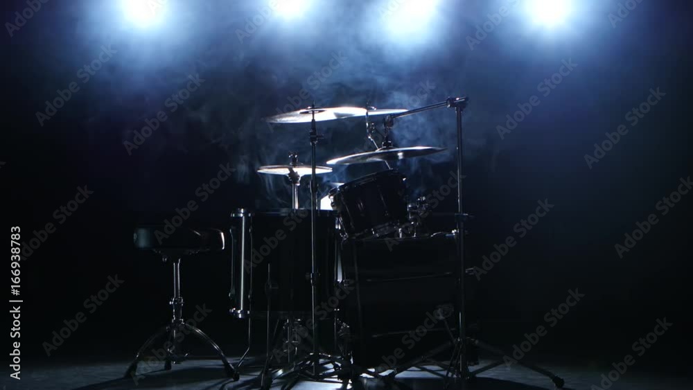 Professional drum set with chair. Black smoky background. Back light. Side view