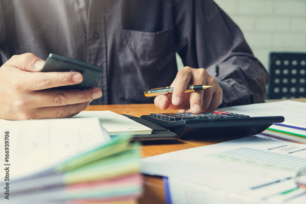 Business and finance concept of office working, Businessman using calculator to calculate analysis chart, Vintage effect Business and finance concept of office working, Businessman using calculator to calculate analysis chart, Vintage effect
