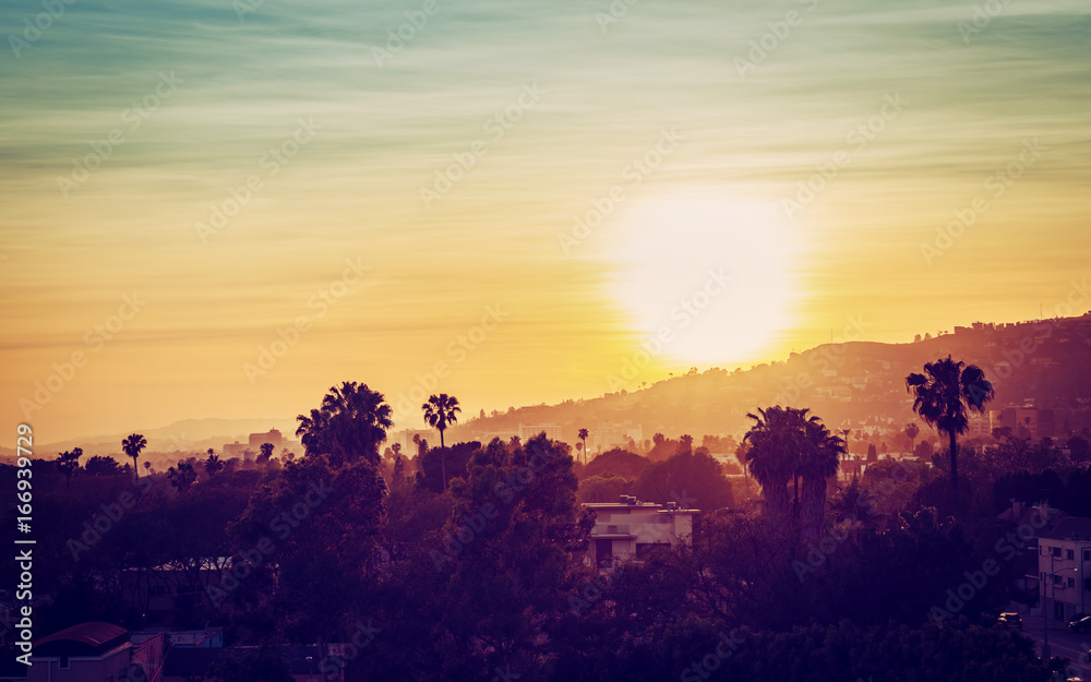 Fototapeta premium Los Angeles mountains with palm trees at sunset. Vintage tone
