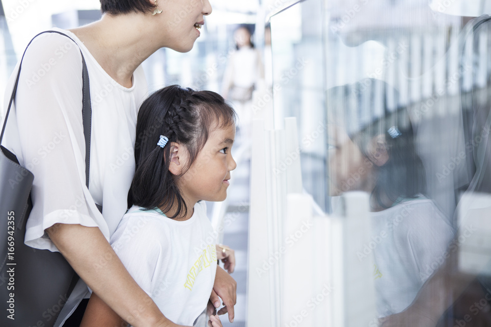 Mother and daughter are watching exhibits together Mother and daughter are watching exhibits together