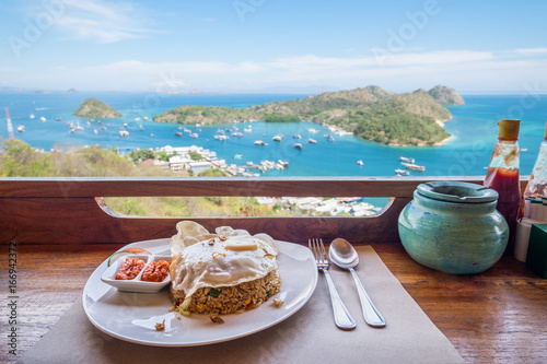 Beautiful sea view with bowl of Local Indonesian food at the restaurant terrace in Flores island, Labuan Bajo, Indonesia photo