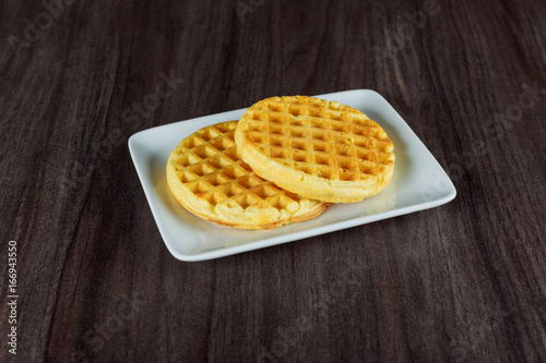 Top view at plate of belgium waffles on a dark wooden rustic background
