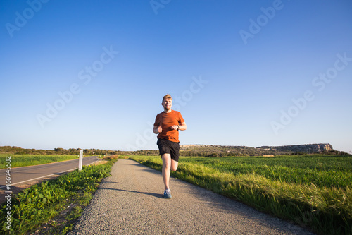 Outdoor cross-country running in summer sunshine concept for exercising, fitness and healthy lifestyle
