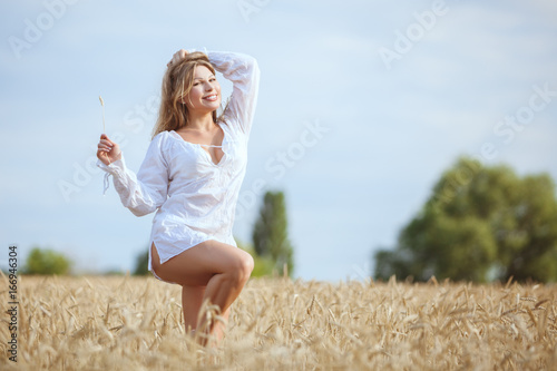 Photos Happy woman in a wheat field enjoys freshness.