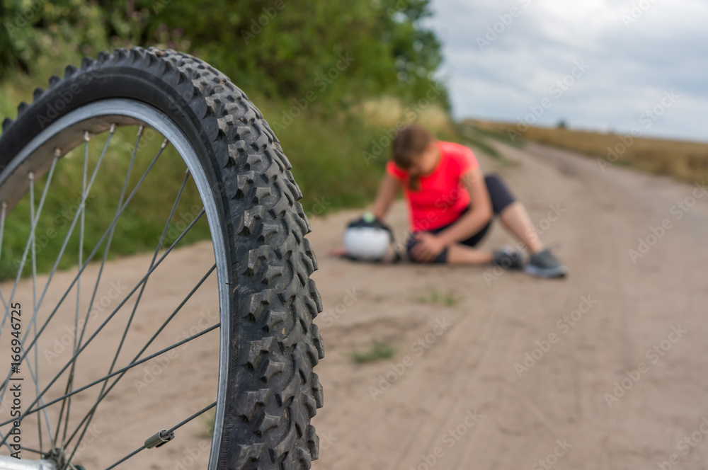 Fototapeta premium Woman with pain in knee after falling down from bicycle