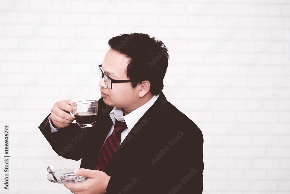 business man drinking coffee in his office alone business man drinking coffee in his office alone