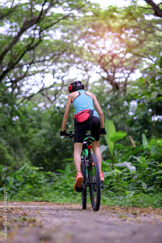 woman riding forward mountain bike in the rainforest adventure