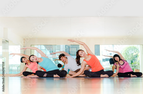 Yoga class in studio room,Group of people doing seated side stretch right poses with calm relax emotion,Meditation pose,Wellness and Healthy Lifestyle