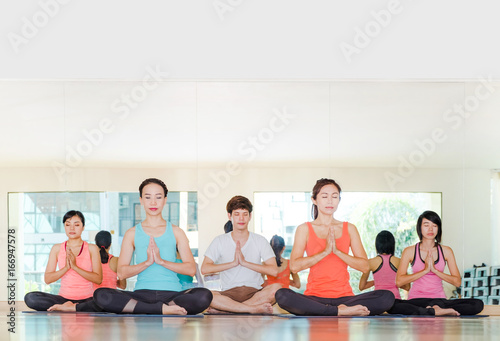 Yoga class in studio room,Group of people doing namaste pose with calm relax emotion,Meditation pose,Wellness and Healthy Lifestyle © weedezign