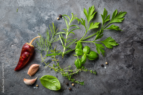 Fotografie Selectionof herbs and spices on stone background