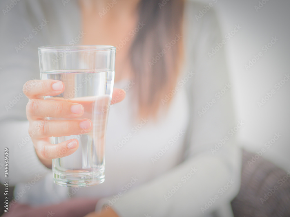 Happy beautiful young woman holding drinking water glass in her hand. Health care concept. Happy beautiful young woman holding drinking water glass in her hand. Health care concept.