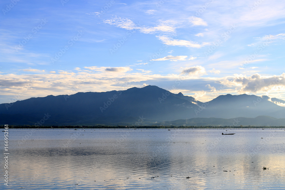 Beautiful sunset and evening sky with mountain and clouds and sunset reflected in the lake for background. Countryside Landscape Under Scenic Colorful Sky At Sunset Dawn Sunrise.