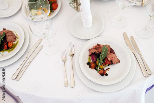 Tasty steak with fried vegetables on table in restaurant on wedding party