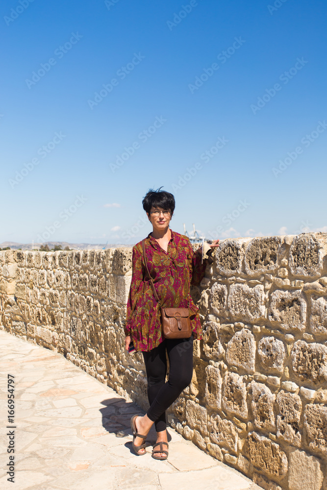 Woman tourist posing near medieval castle.