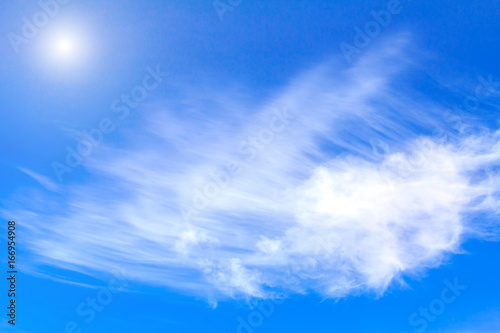 Blue sky background with white clouds rain clouds and sunshine on sunny summer or spring day.