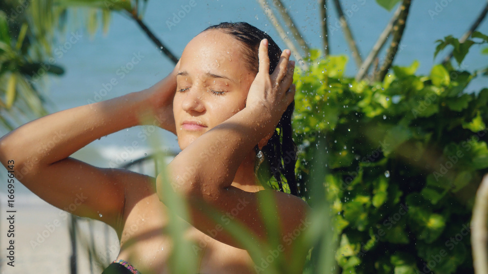 Beautiful young woman in outdoor shower. Sensual and Seductive has a washing hair on summer holidays. Beautiful young woman in outdoor shower. Sensual and Seductive has a washing hair on summer holidays.