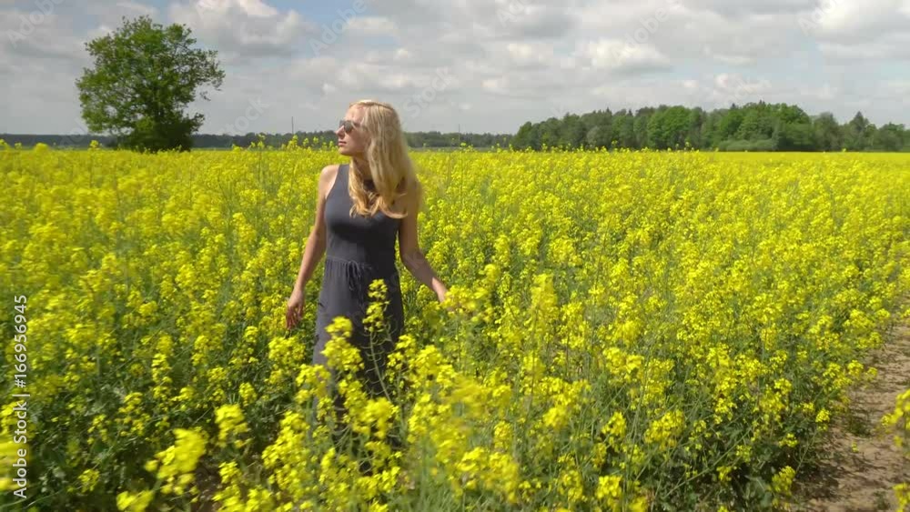 young blonde woman posing in beautiful rapeseed field young blonde woman posing in beautiful rapeseed field