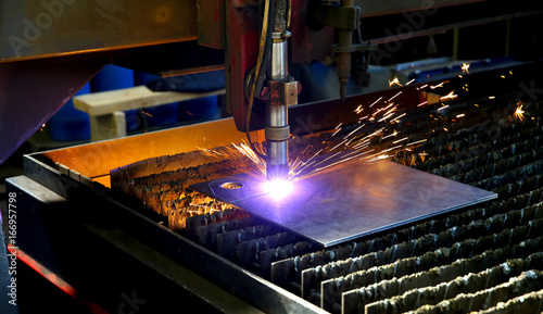 Industrial cnc plasma cutting of metal plate. Sparks fly. Closeup photo