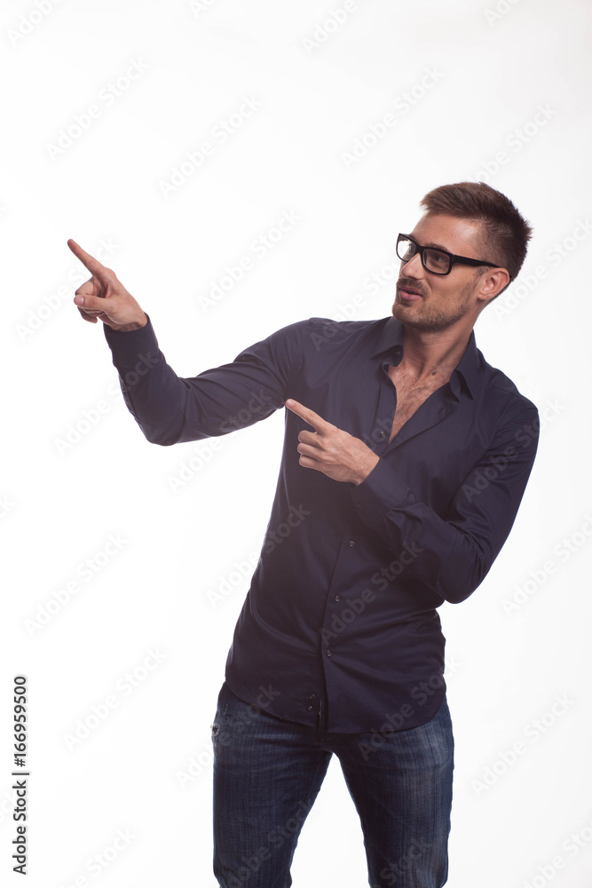 Young jocular man portrait of a confident businessman showing by hands on a gray background. Ideal for banners, registration forms, presentation, landings, presenting concept. Young jocular man portrait of a confident businessman showing by hands on a gray background. Ideal for banners, registration forms, presentation, landings, presenting concept.