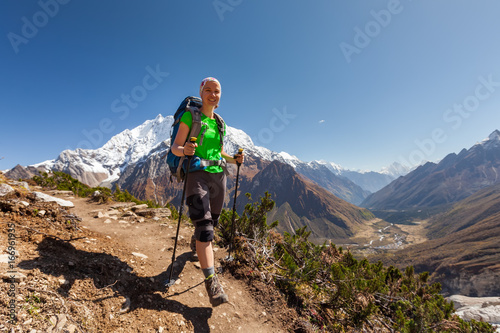 Hiker is climbig to Manaslu base camp in highlands of Himalayas on Manaslu circuit photo