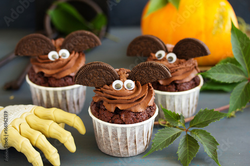 Chocolate muffins, with a chocolate cream in the form of bat on Halloween. photo