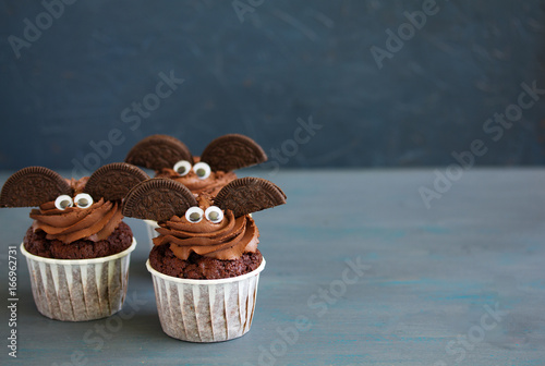 Chocolate muffins, with a chocolate cream in the form of bat on Halloween.