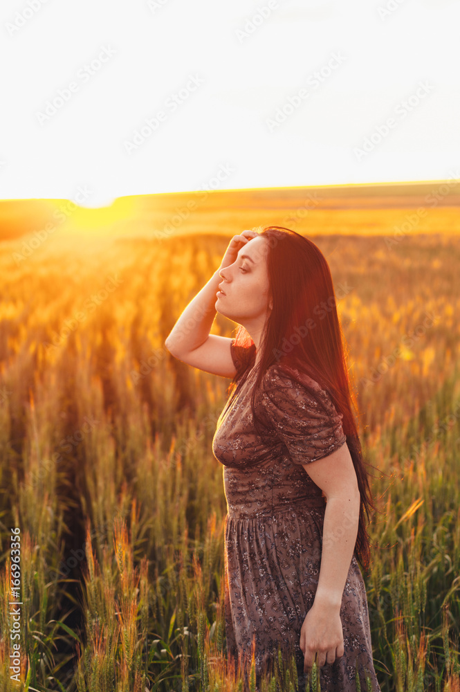 Beautiful young woman at sunset in the field Beautiful young woman at sunset in the field