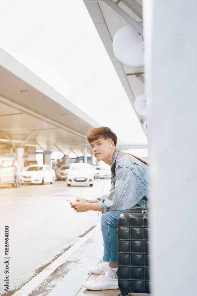 Young asian passenger waiting for taxi at the airport Young asian passenger waiting for taxi at the airport