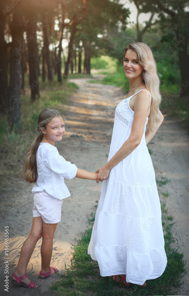 Portrait of mother and daughter while walking in nature in summer. Portrait of mother and daughter while walking in nature in summer.