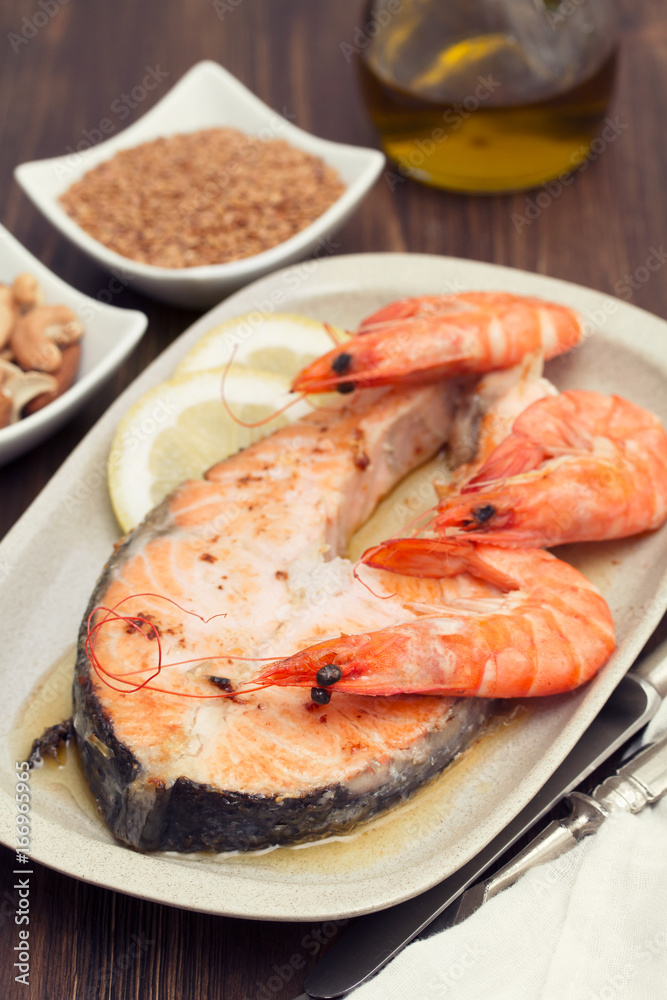 fried salmon with shrimps on white dish on wooden background fried salmon with shrimps on white dish on wooden background