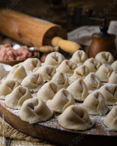 Dumplings with meat in process of cooking. Ingredients for cooking. Traditional russian and ukrainian food.